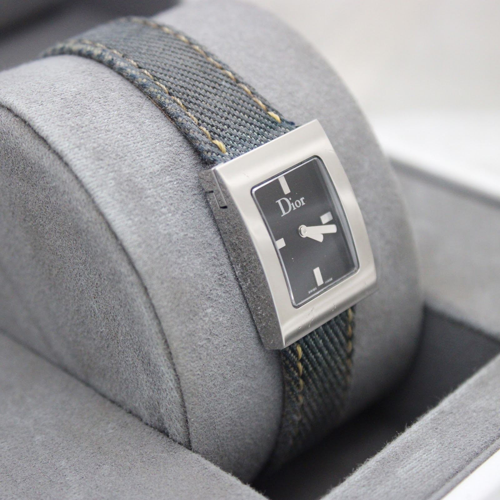 Different angled view of Dior D78-109 on cushion, highlighting the polished steel case and minimalist black dial.