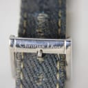 Close-up of the original Christian Dior signed buckle on the denim strap.
