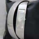 Front view of the polished stainless steel Calvin Klein bangle watch with a minimalist silver dial, displayed on a black cushion.
