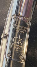Close-up of the engraved case back showing 'Water Resistant 30M/100FT', 'All Stainless Steel', 'Swiss Made', 'ck Calvin Klein', and model number K50234.