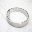 Side view of the polished stainless steel bangle watch, showing the internal clasp mechanism.