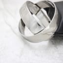 Angled view of the sleek, polished stainless steel Calvin Klein bangle watch resting on a black cushion.