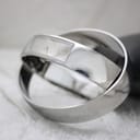 Dynamic angled shot of the minimalist Calvin Klein bangle watch, highlighting its reflective stainless steel finish.