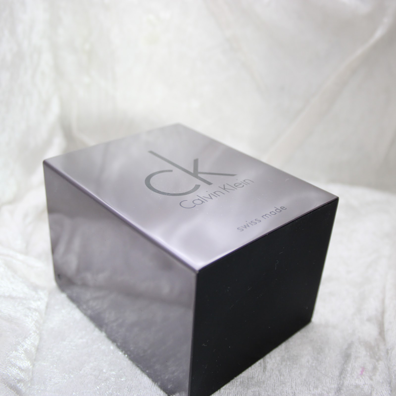 Top view of the black Calvin Klein watch box, featuring the 'ck Calvin Klein swiss made' logo on the lid.