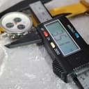 Digital caliper displaying 35.1mm measurement next to the Mercedes-Benz SLK watch case.