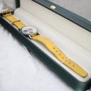 Mercedes-Benz SLK chronograph watch with yellow strap presented in a dark green watch box.