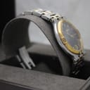 Another angled side view of the Gucci 9000G watch on a grey display cushion, focusing on the bracelet and case side.
