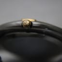 Macro shot of the gold-tone crown of the Gucci 9000G, featuring the embossed Gucci logo.