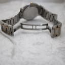 View of the open butterfly clasp on the two-tone bracelet of the Gucci 9000G, laid flat on a white surface.