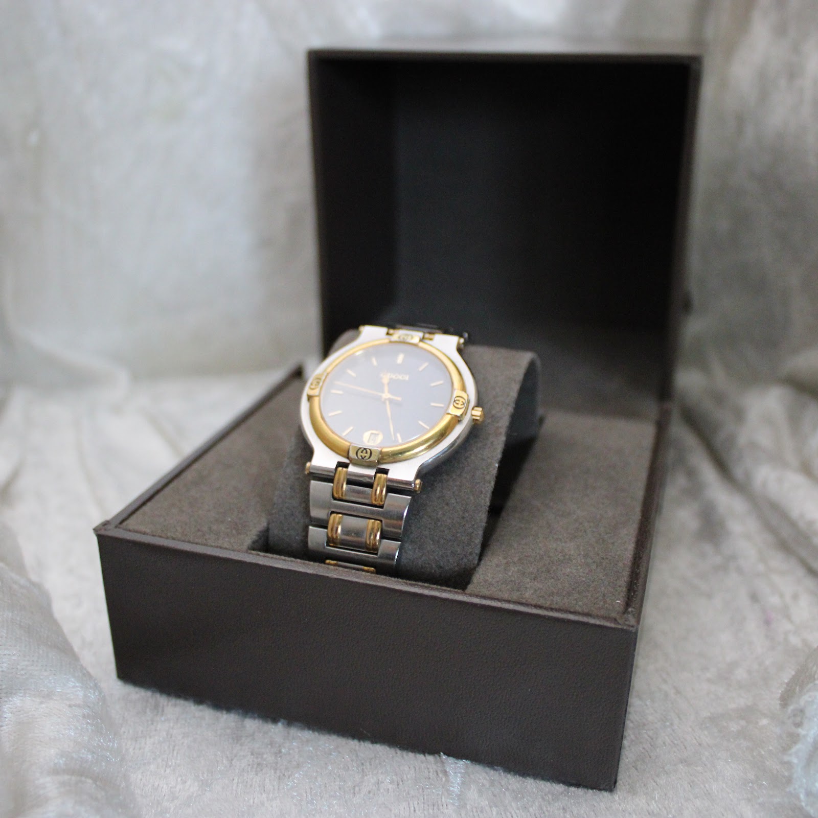 The Gucci 9000G watch displayed inside its original brown Gucci presentation box with a grey interior.