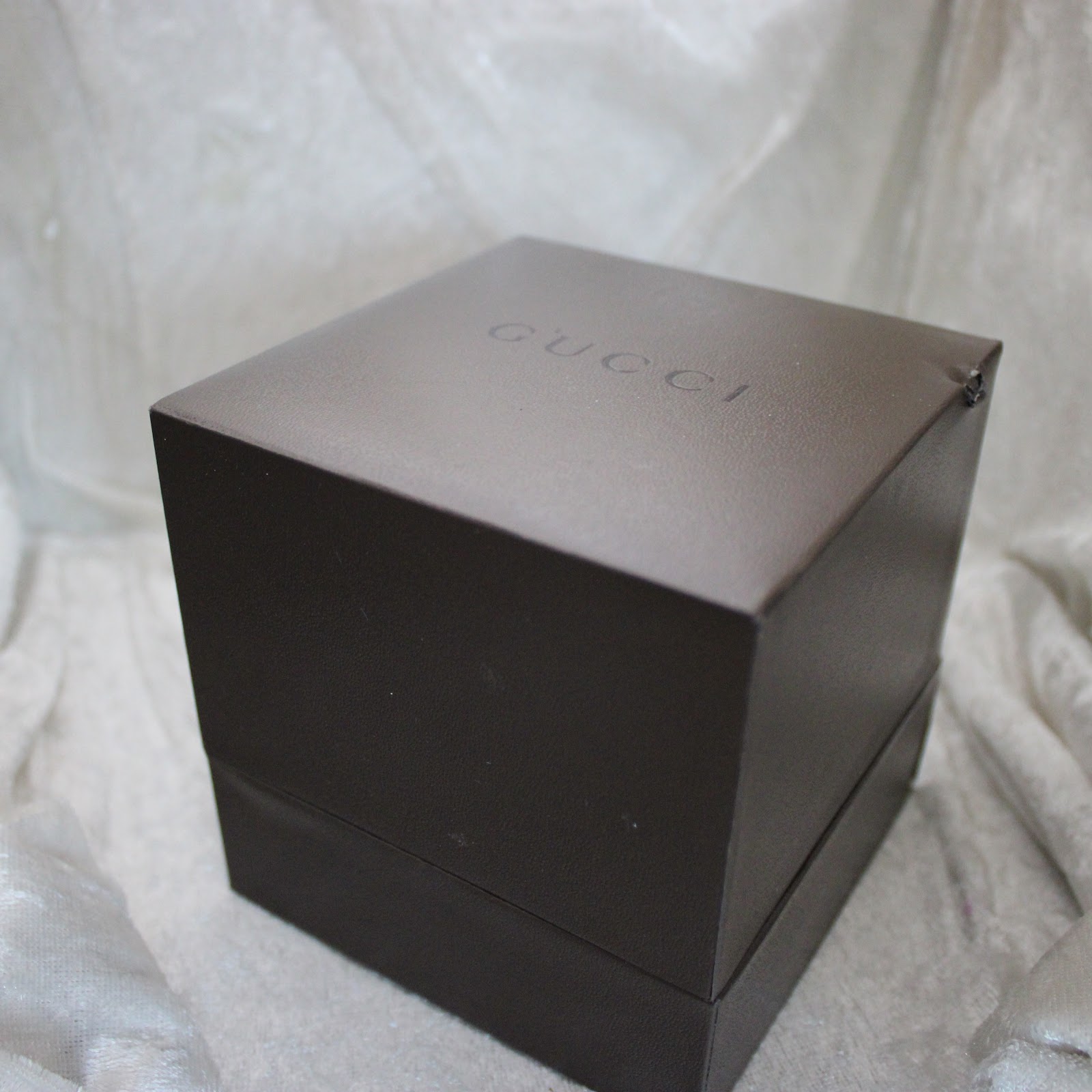 Top view of the closed original brown Gucci watch box, with the 'GUCCI' logo embossed on the lid.