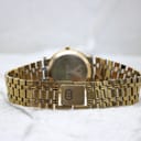 Rear view of the gold-tone Gucci bracelet with a signed butterfly clasp showing the interlocking G logo.
