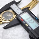 Digital caliper measuring the case diameter of the Gucci watch, displaying 33.22mm on a white background.