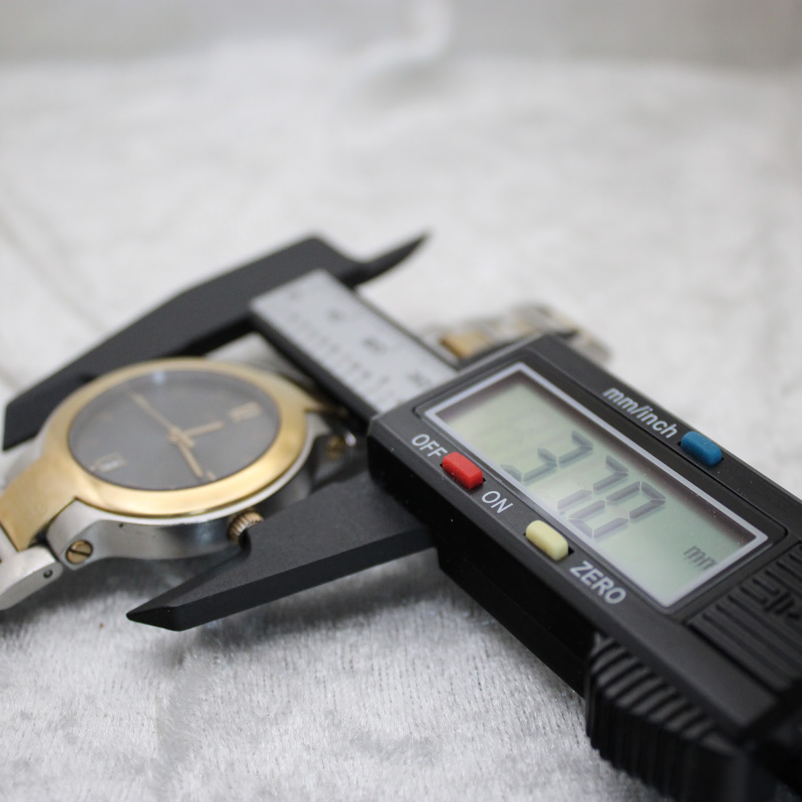 Close-up of a digital caliper measuring the watch case, displaying a precise diameter of 37.07mm.