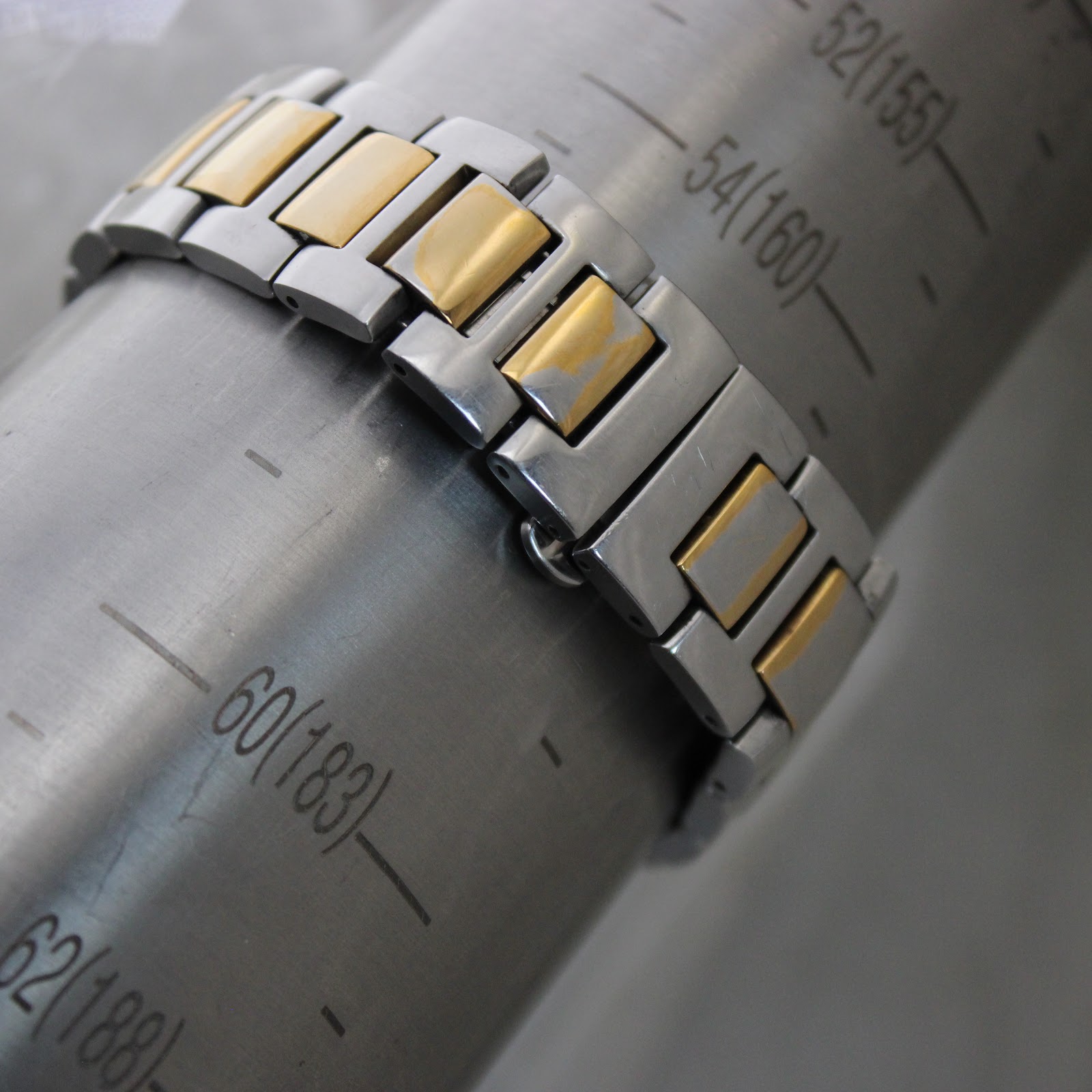 Close-up of the two-tone Gucci bracelet on a wrist sizing gauge, indicating a wrist circumference fit of approximately 17.2cm.