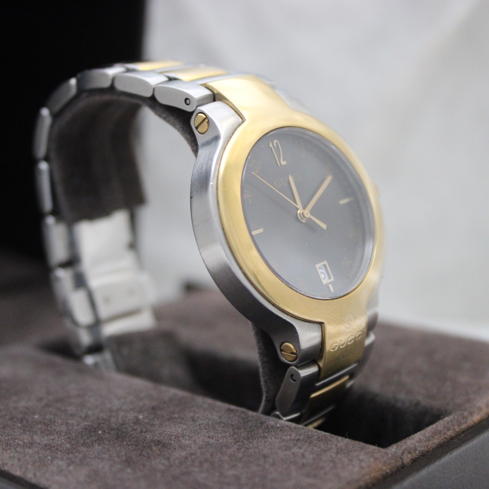 Another angled view of the Gucci 8900M, focusing on the two-tone case and bracelet details, resting in its box.