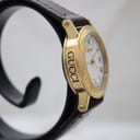 Angled side view of the Gucci 7200L watch, showing the 'GUCCI' engraving on the case side.