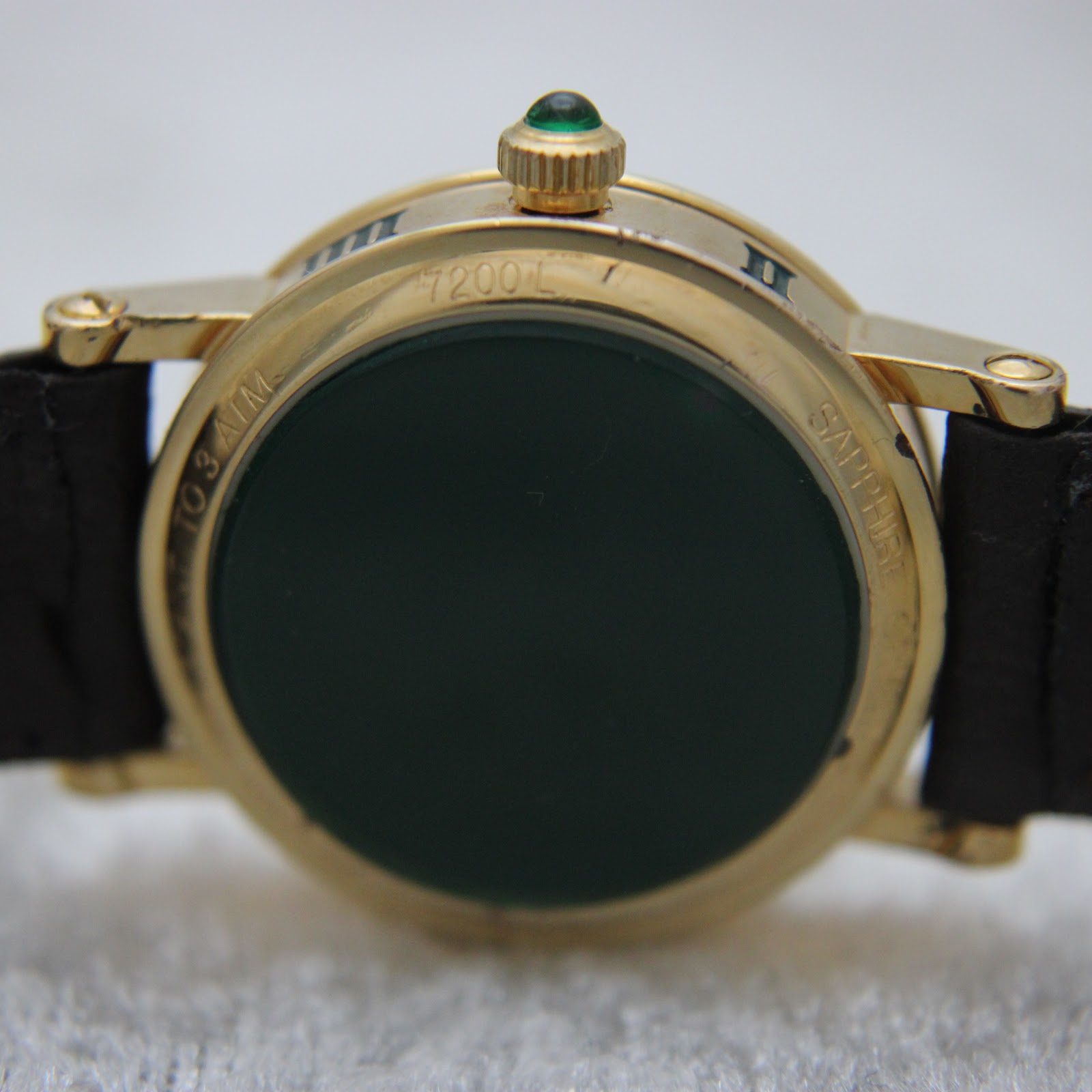 Close-up of the watch case back, detailing model number 7200L, 'TO 3 ATM' water resistance, and 'SAPPHIRE' crystal markings.