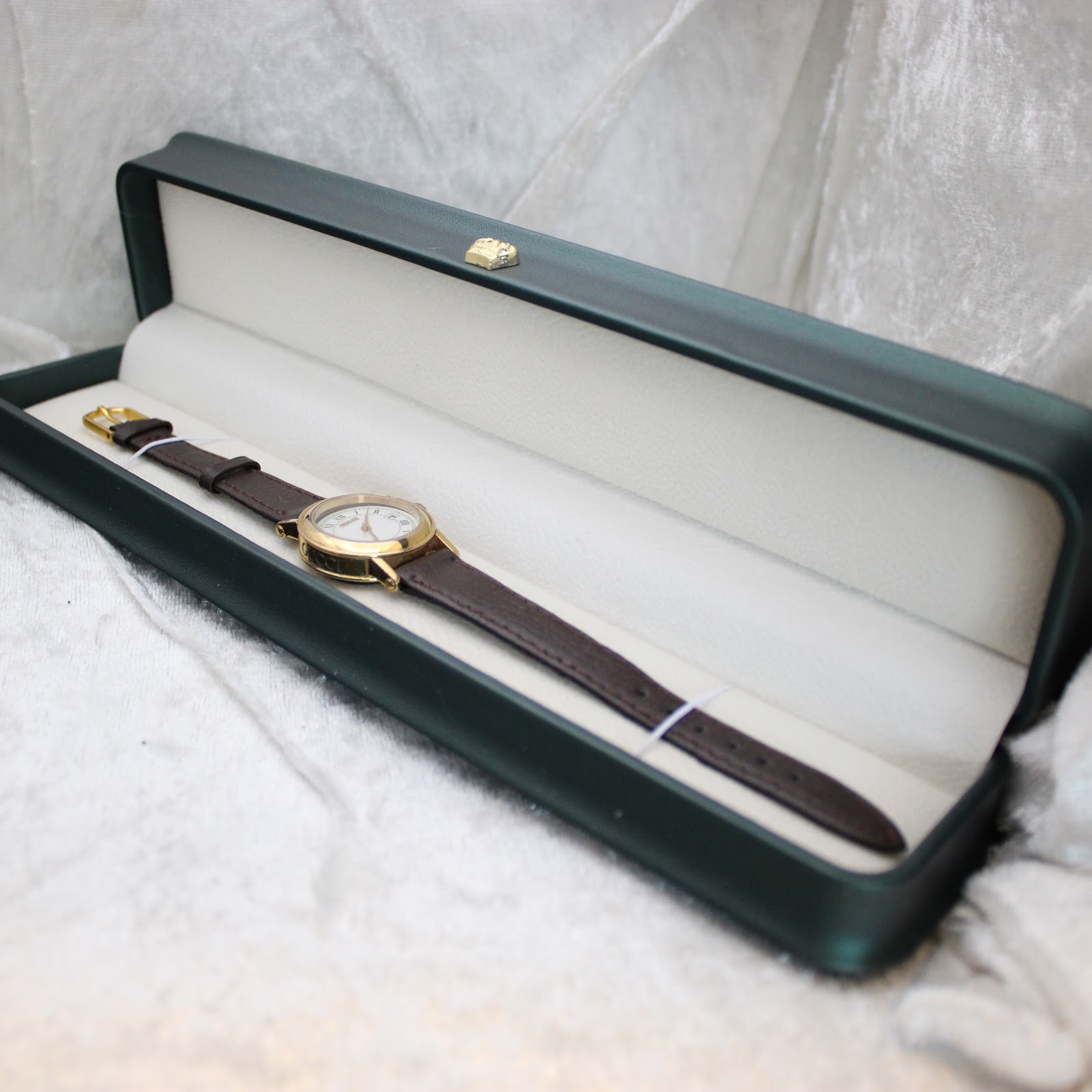 The Gucci 7200L watch neatly presented inside a dark green display box with a contrasting light interior.