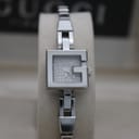 Front view of Gucci 102 G-frame watch on a display stand, showing silver dial and bracelet.