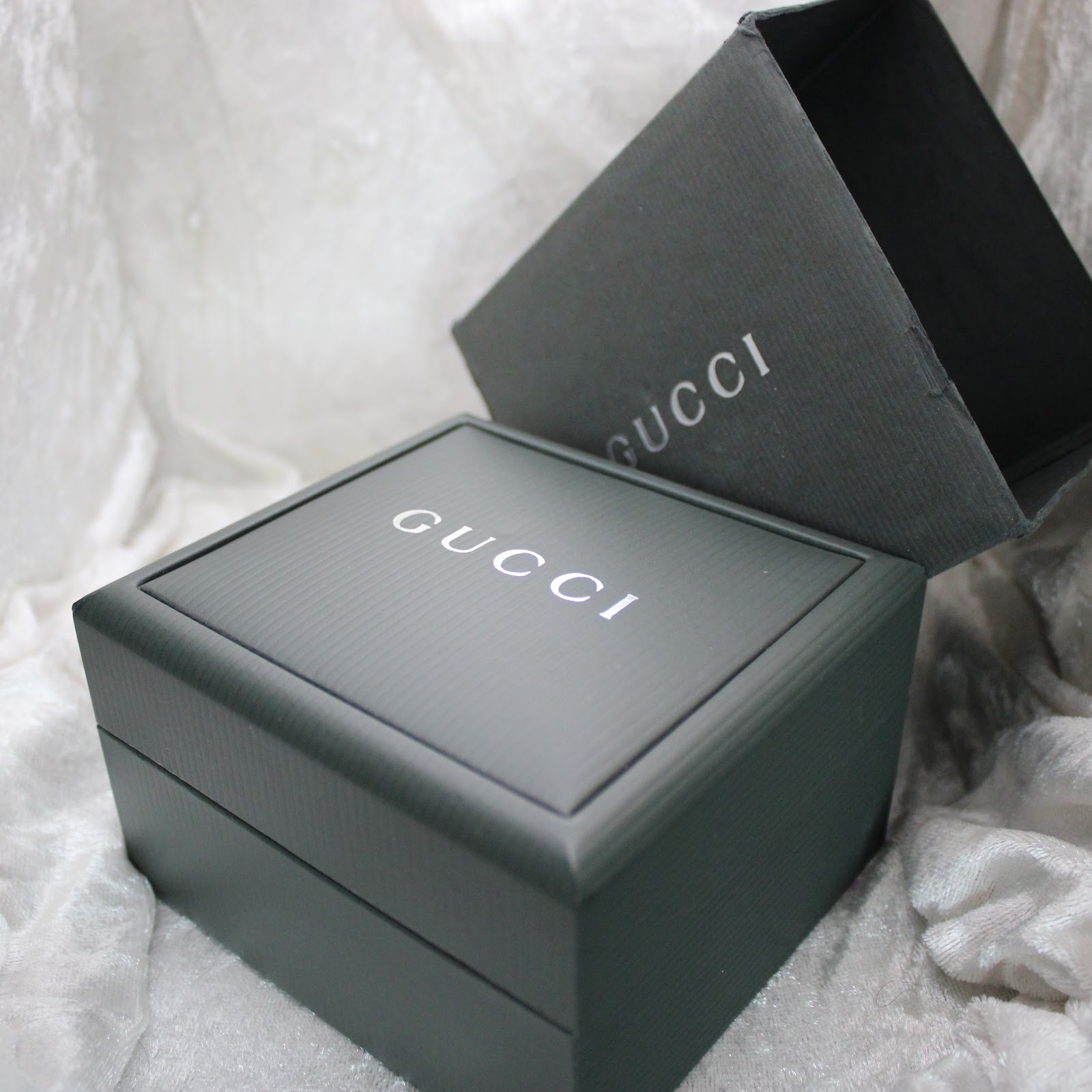 Close-up of the dark green original Gucci presentation box with its outer packaging.
