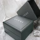 Close-up of the dark green original Gucci presentation box with its outer packaging.