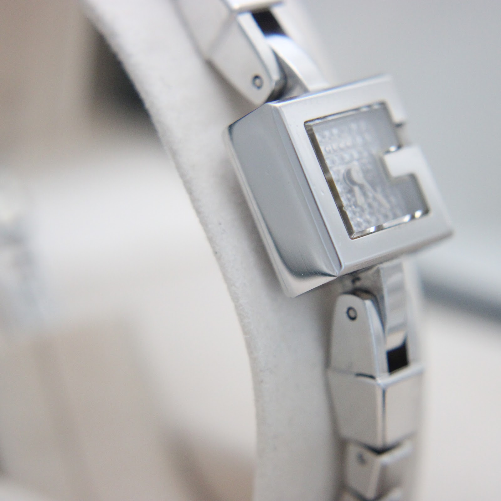 Another side view of the Gucci 102 G-frame watch case and bracelet, highlighting the polished finish.