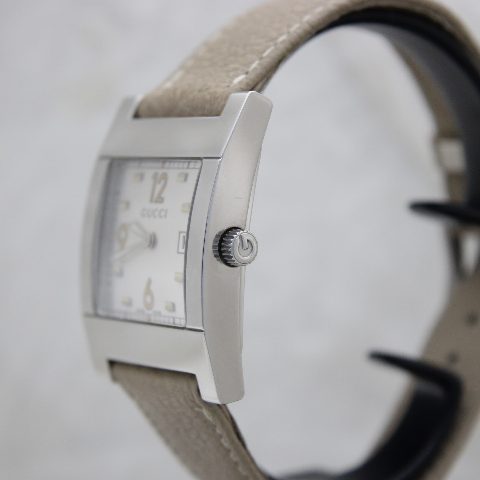 Side view of the Gucci 7700M showing the polished stainless steel case and signed crown.