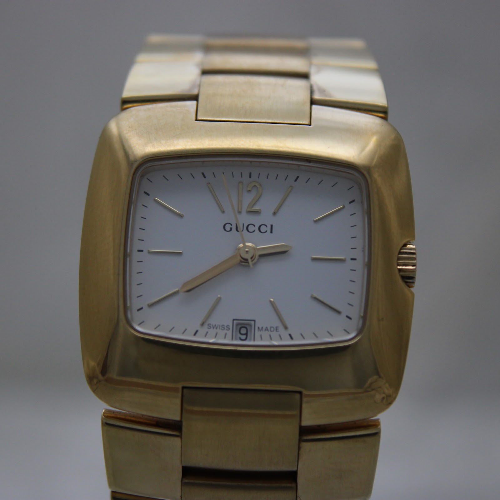 Slightly closer front view of the gold-tone Gucci 8500L dial, showing the 12 o'clock Arabic numeral and date window.