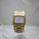 Full front view of the gold-tone Gucci 8500L watch on a clear stand, highlighting its integrated bracelet.