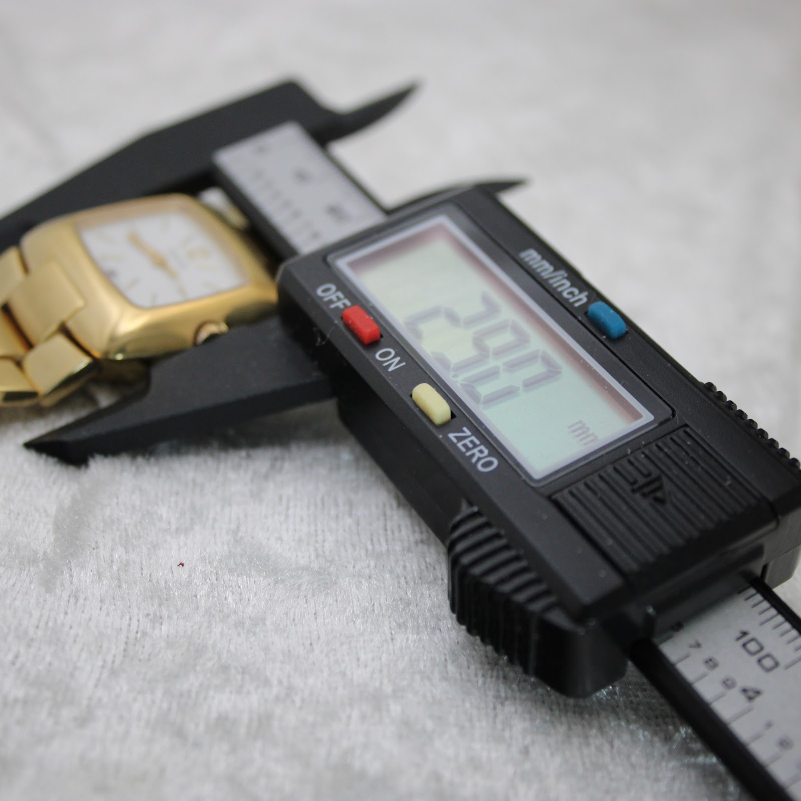 Digital caliper measuring the watch case, displaying a precise diameter of 29.0mm.