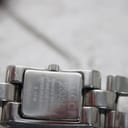 Close-up of the watch case back, showing 'GUCCI 2305L', 'SWISS MADE', 'STAINLESS STEEL', 'WATER RESISTANT 3 ATM', and serial number '0061052'.