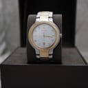 Front view of the two-tone Gucci 8900M watch with a white dial and gold-tone bezel, presented in its original brown box.