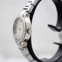 Side profile of the Gucci 8900L watch, highlighting the signed crown and two-tone case details on a watch stand.