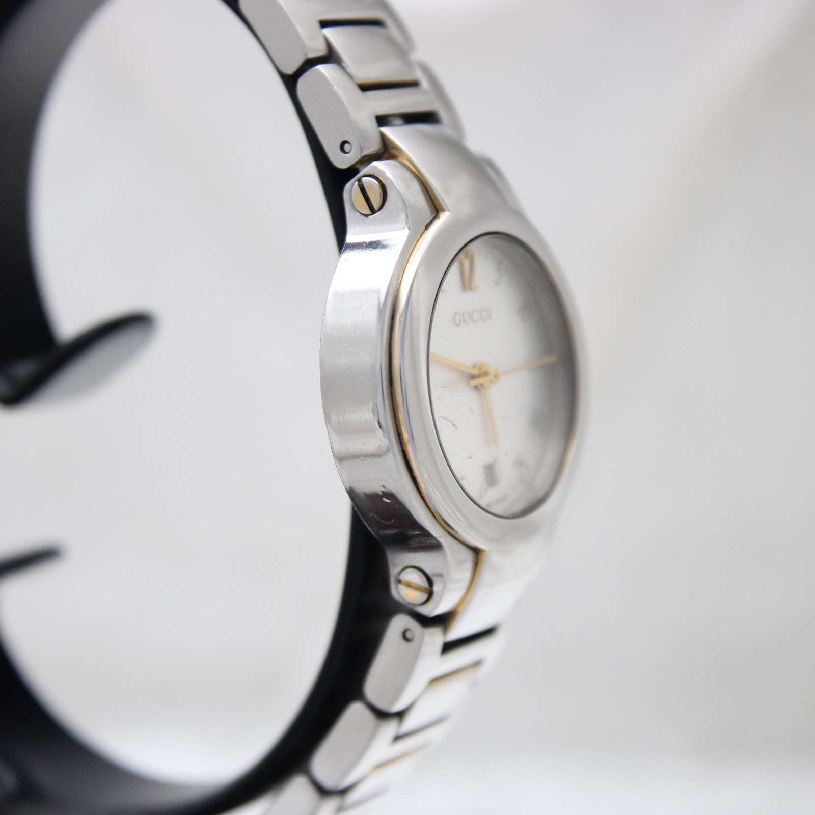 Angled side view of the Gucci 8900L watch, showcasing the polished bezel and integrated two-tone bracelet links.