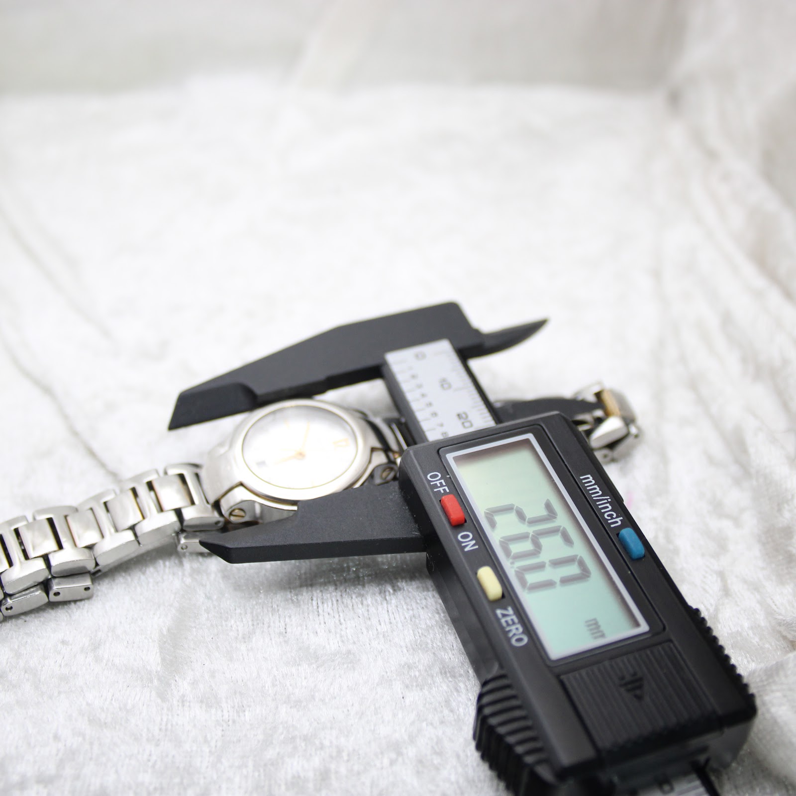 Digital caliper measuring the case diameter of the Gucci 8900L watch at 26.0mm, confirming its size.