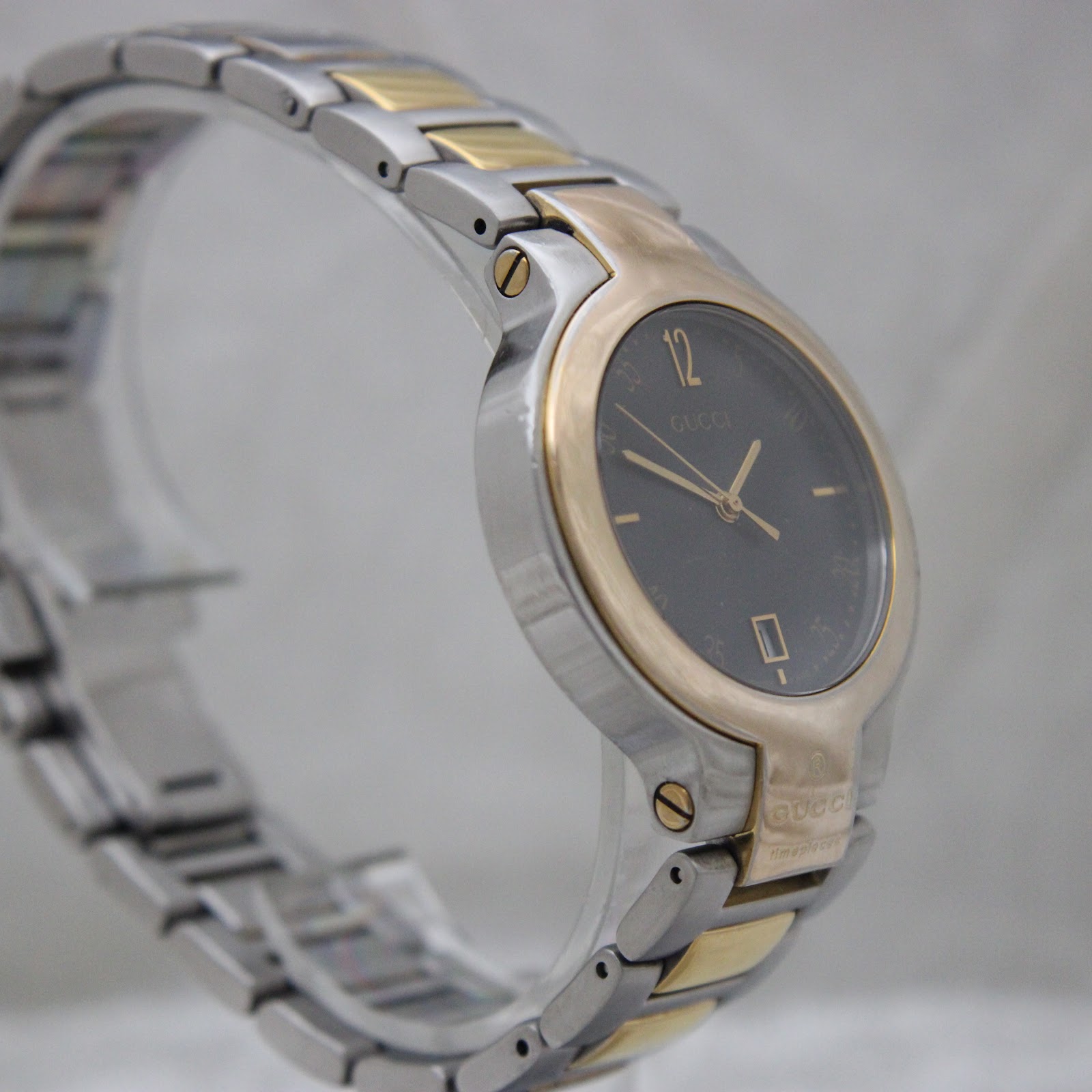 Three-quarter view of the Gucci 8900M watch and its integrated two-tone bracelet, showing the sleek design.