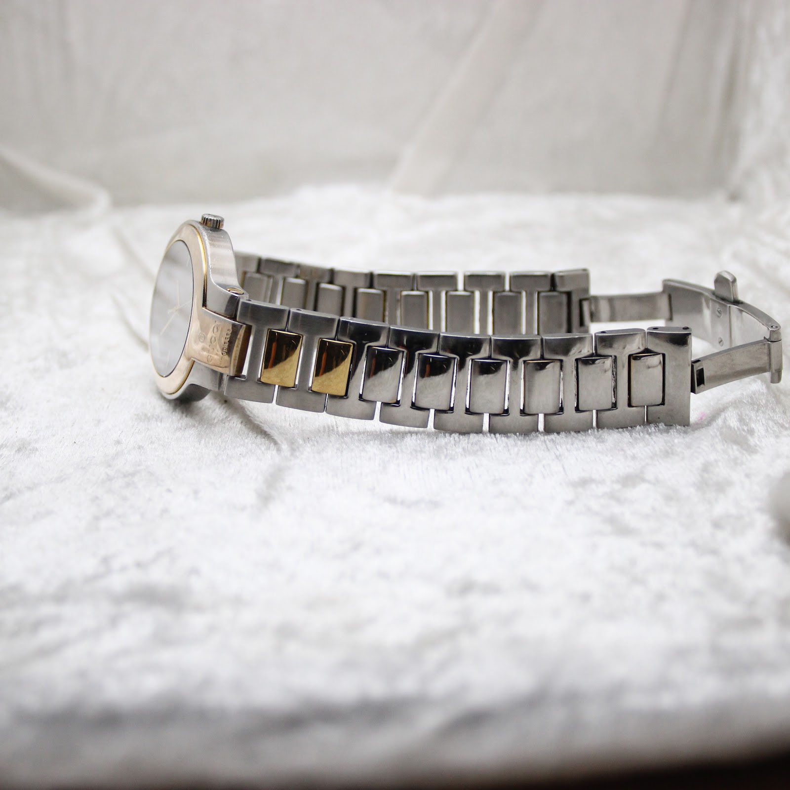 Side profile of the Gucci 8900M watch and bracelet, emphasising the alternating silver and gold-tone links.