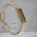 Another angled side view of the gold Gucci 1500L watch on a stand, highlighting the case shape and bracelet.