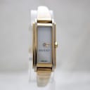 Front-facing view of the gold-tone and stainless steel Gucci 109 bangle watch with a white rectangular dial.