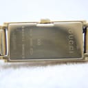 Detailed close-up of the watch's snap-back case, showing "GUCCI", "109", "STEEL", and serial number engraving.