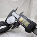 Digital caliper accurately measuring the watch's case diameter at 37.0mm.
