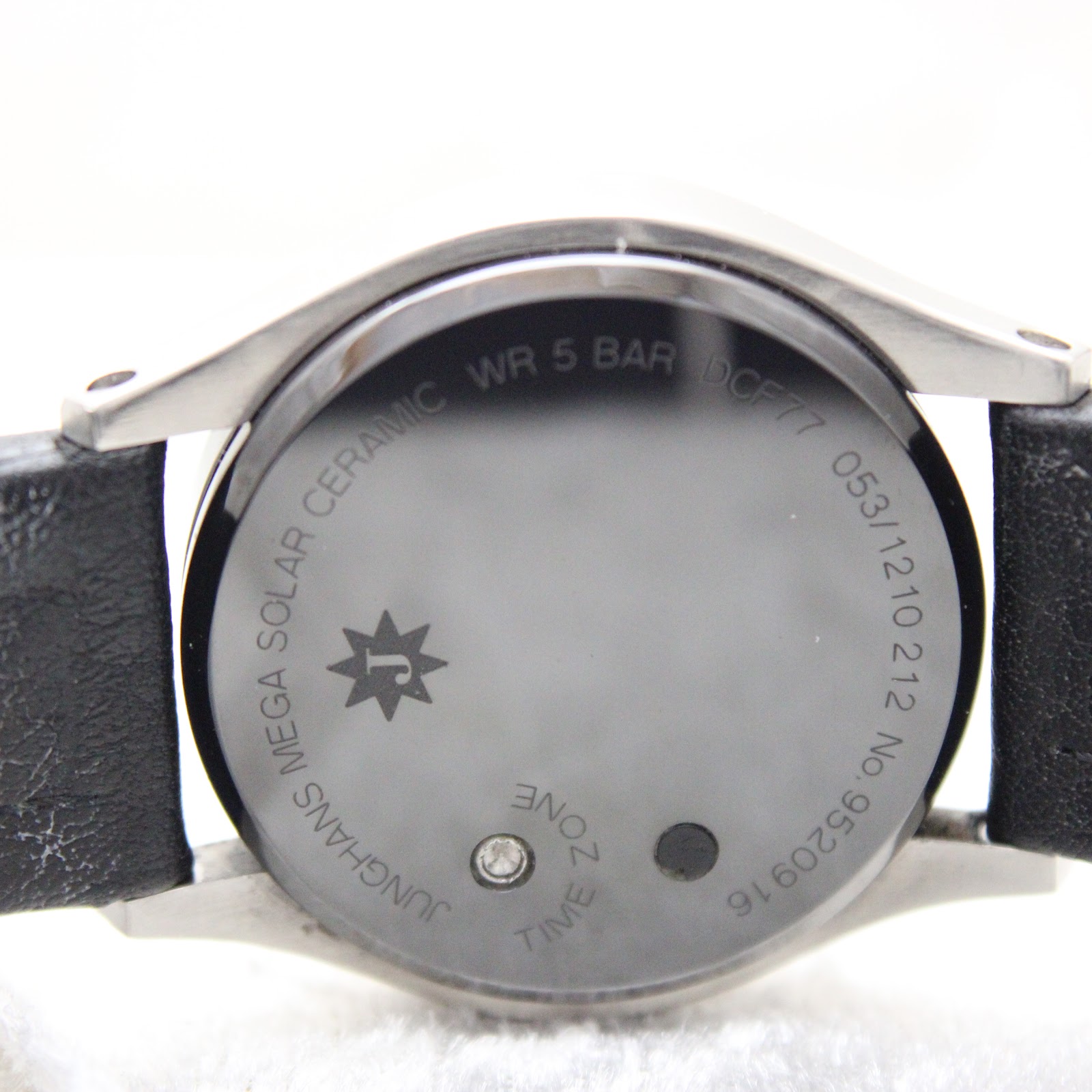 Close-up of the ceramic case back, with engravings for "Junghans Mega Solar Ceramic", "WR 5 BAR", "DCF77", and control buttons.