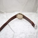 View from the back of the watch, showing the brown leather strap laid flat and the case back details.
