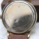 Exterior of the case back, engraved with "BULOVA N8", "WATER RESISTANT", "BASE METAL BEZEL", and "10 KT R.G.P. BACK", with visible scratches.