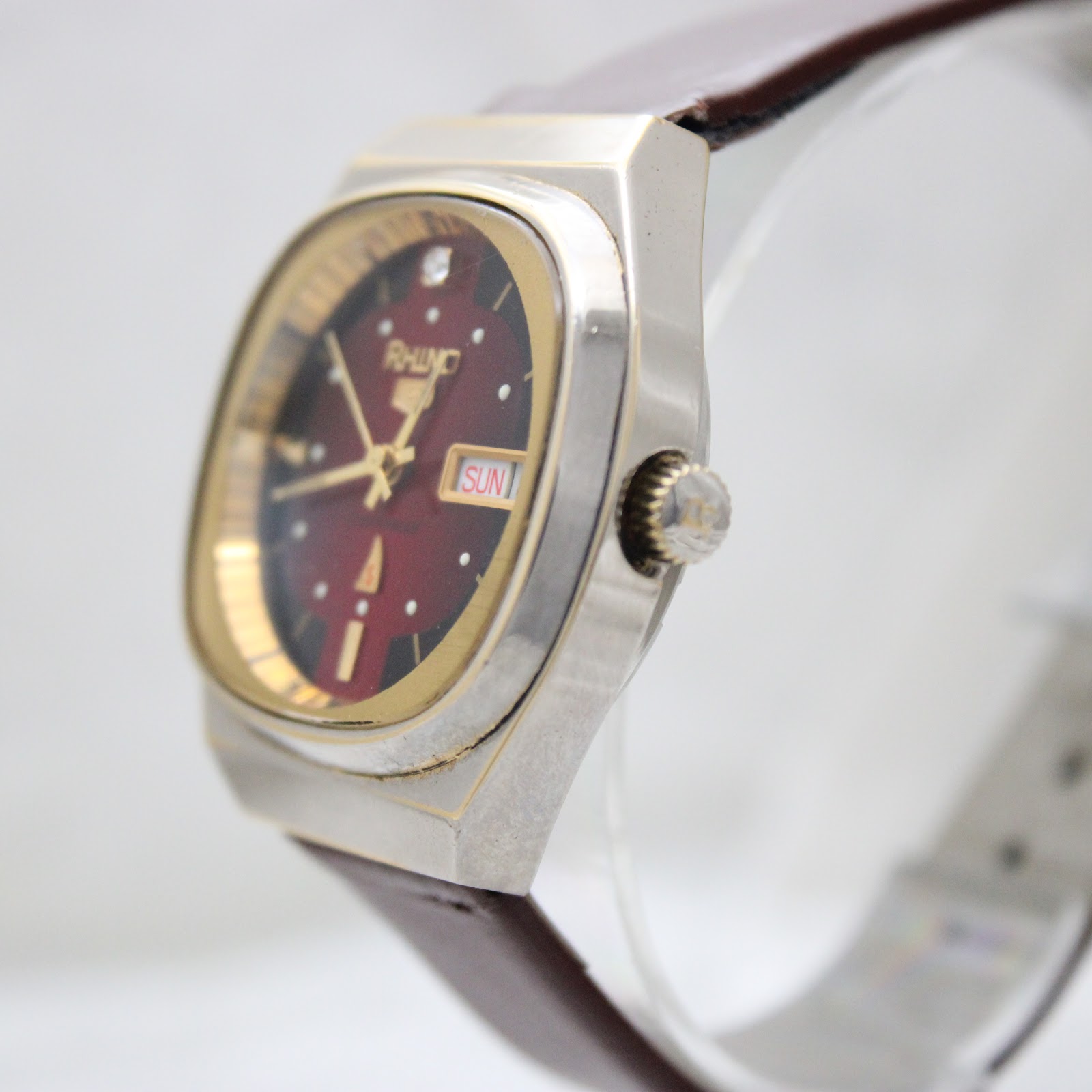 Side-angle view of the Rhino automatic watch, highlighting its faceted tonneau case shape and the fluted crown.
