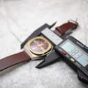 The watch with a digital caliper displaying a precise case size measurement of 38.3mm.