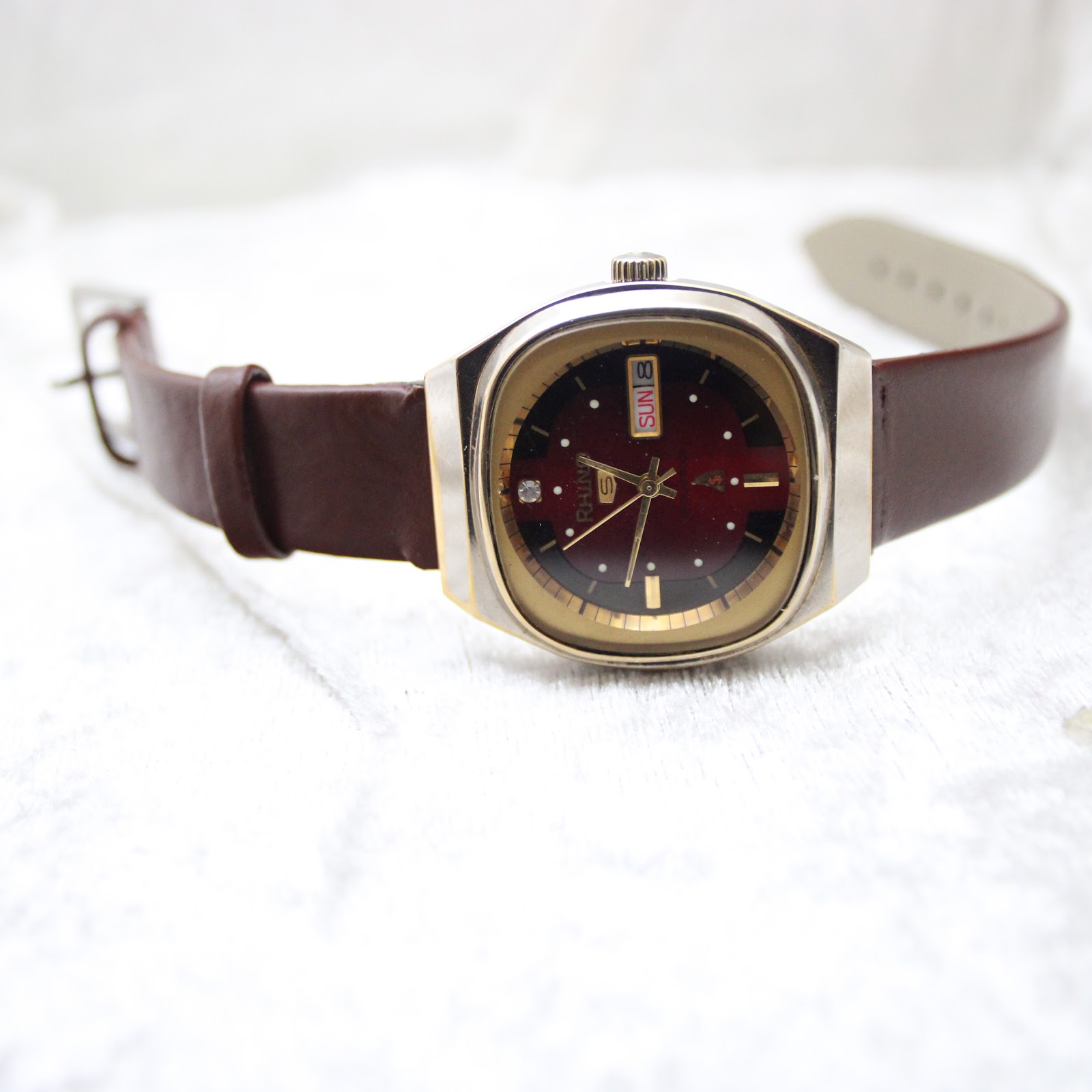 Full view of the Rhino automatic watch with its brown leather strap extended, presented on a light background.