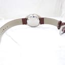 Rear view of the watch showing the brown genuine leather strap with an 18mm lug width marking, and the stainless steel case back.