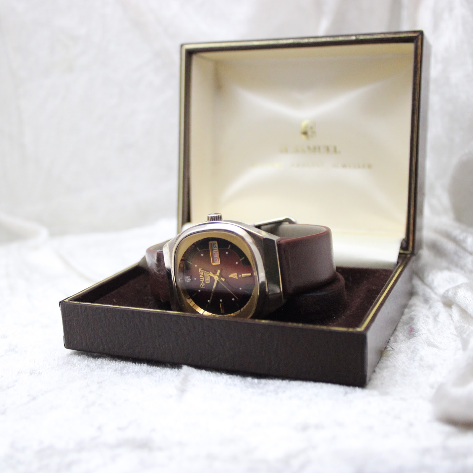 The Rhino automatic watch displayed open in a vintage H. Samuel Jewellery box, showing its side profile and strap.